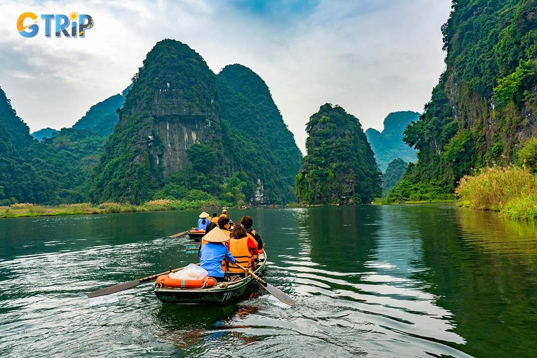 Unrecongnisable people take boat on river at Trang An at Ninh Binh